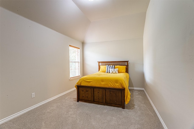 bedroom with lofted ceiling and light colored carpet