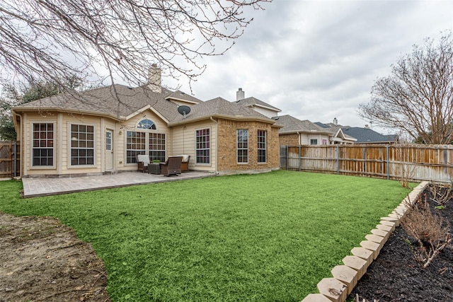 back of house with a yard and a patio