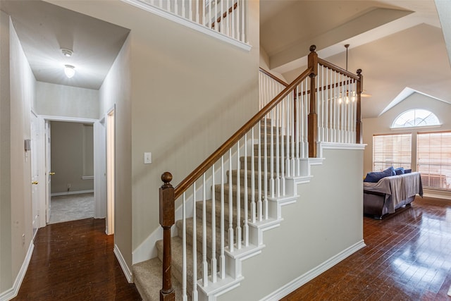 stairs with hardwood / wood-style flooring and high vaulted ceiling