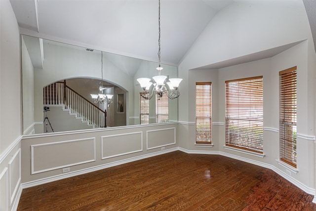 interior space with an inviting chandelier, hardwood / wood-style floors, and high vaulted ceiling