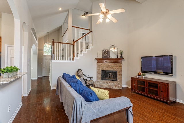 living room with ceiling fan, high vaulted ceiling, a fireplace, and dark hardwood / wood-style flooring