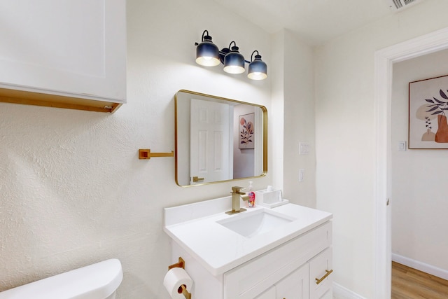 bathroom with vanity, hardwood / wood-style flooring, and toilet