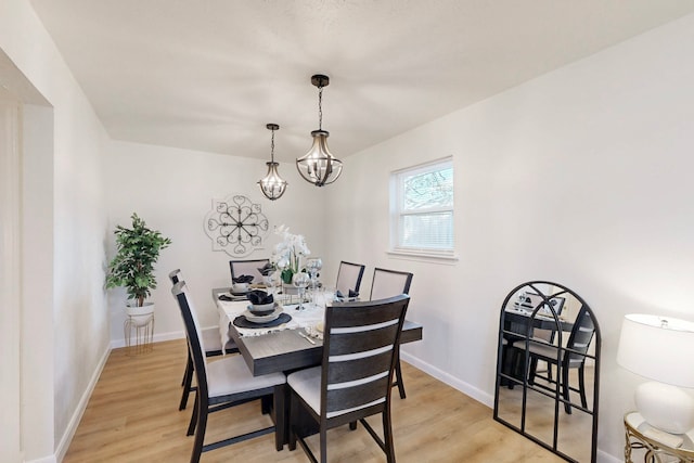 dining area featuring a chandelier and light wood-type flooring