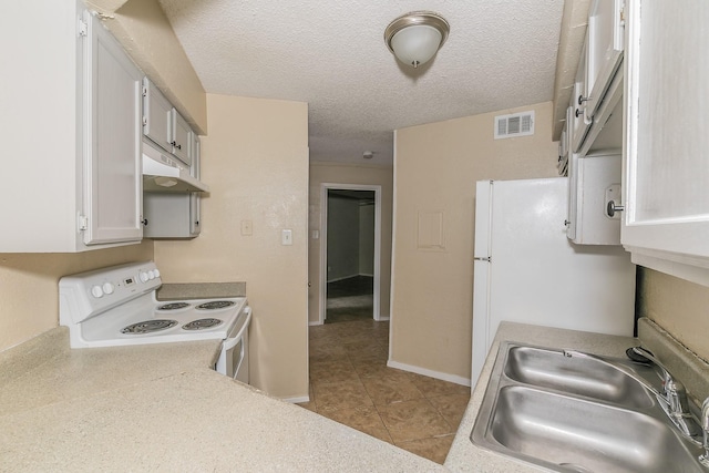 kitchen featuring sink, white appliances, white cabinetry, a textured ceiling, and light tile patterned flooring