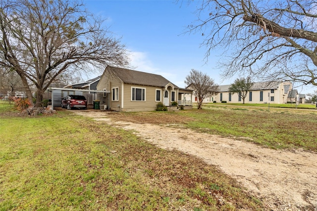 view of side of home with a carport and a lawn