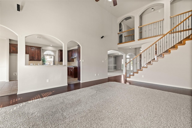 1300 Spanish Needle Trl, Fort Worth, TX 76177 - unfurnished living room with stairs, dark wood-style flooring, a high ceiling, and a ceiling fan