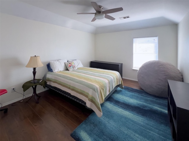 bedroom with baseboards, visible vents, and wood finished floors