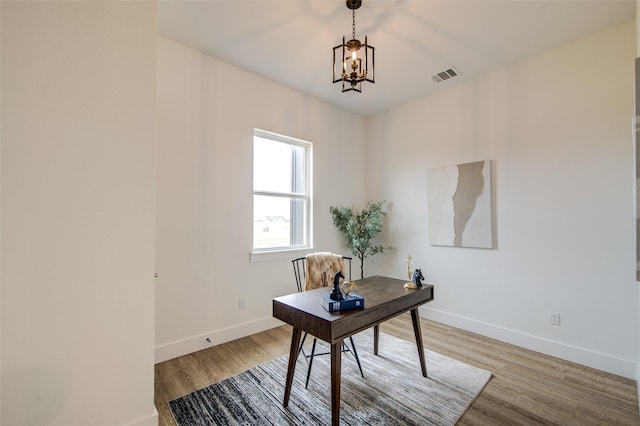 home office with a notable chandelier, light wood-style flooring, visible vents, and baseboards