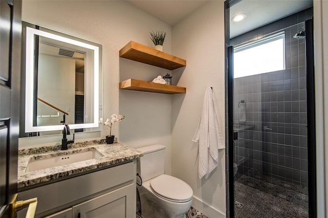 bathroom featuring visible vents, a stall shower, vanity, and toilet