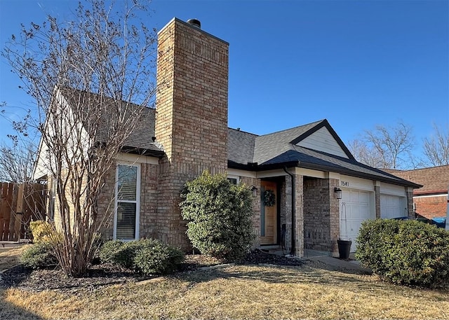 view of front of home with a garage, a shingled roof, a chimney, and a front lawn