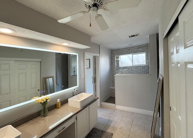 bathroom with visible vents, tile patterned floors, a textured ceiling, vanity, and a walk in shower