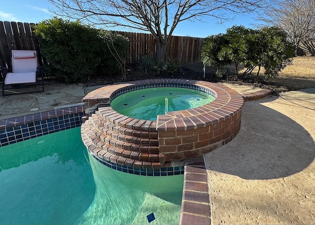 view of pool featuring a patio area, fence, a fenced in pool, and an in ground hot tub