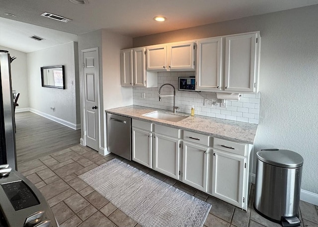 kitchen with a sink, visible vents, white cabinetry, and stainless steel dishwasher