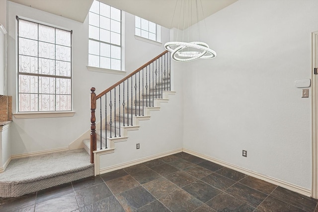 staircase featuring a notable chandelier