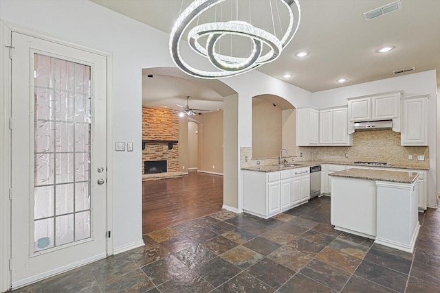 kitchen featuring white cabinetry, sink, tasteful backsplash, and a fireplace