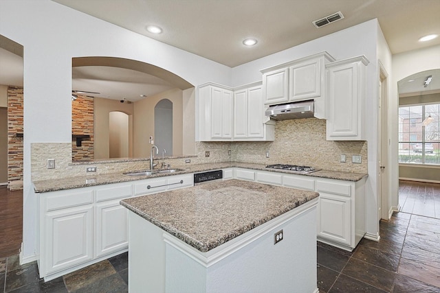 kitchen with sink, stainless steel gas stovetop, kitchen peninsula, and white cabinets