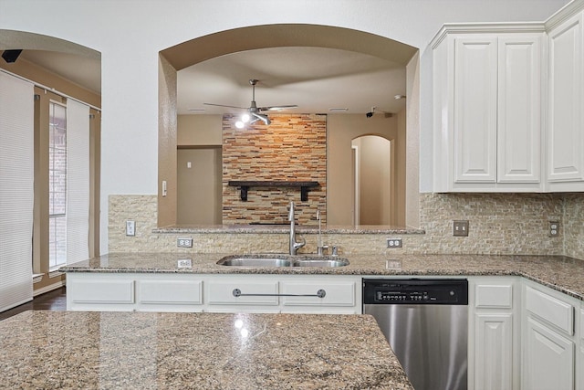 kitchen featuring sink, light stone counters, tasteful backsplash, stainless steel dishwasher, and white cabinets