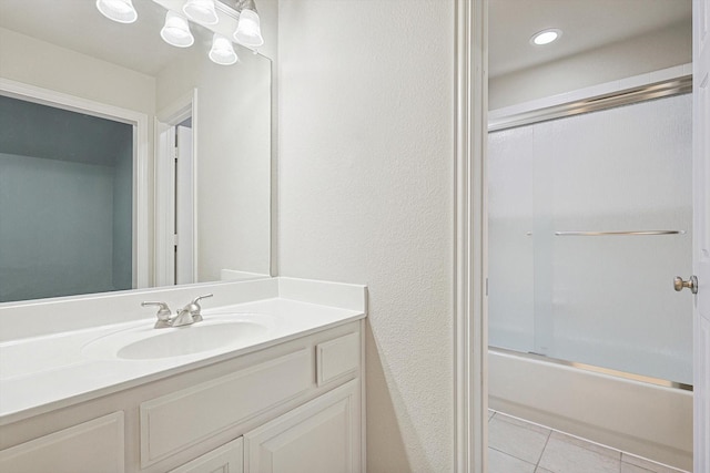 bathroom featuring vanity, a notable chandelier, tile patterned flooring, and bath / shower combo with glass door