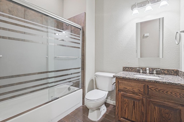 full bathroom featuring vanity, shower / bath combination with glass door, and toilet