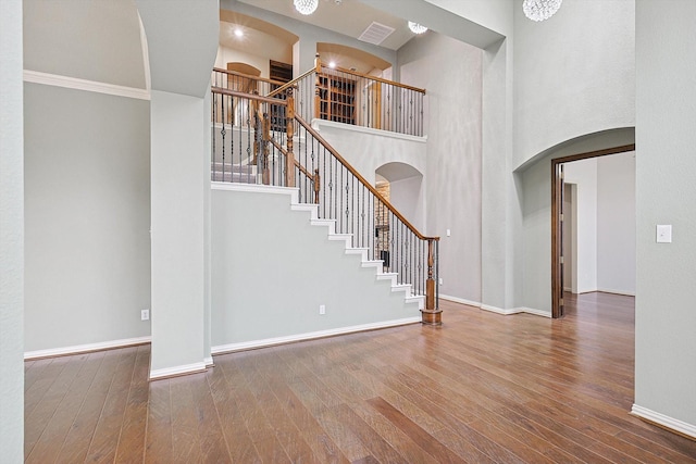 entrance foyer featuring a towering ceiling and hardwood / wood-style floors