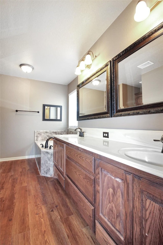 bathroom featuring vanity, hardwood / wood-style flooring, and a tub