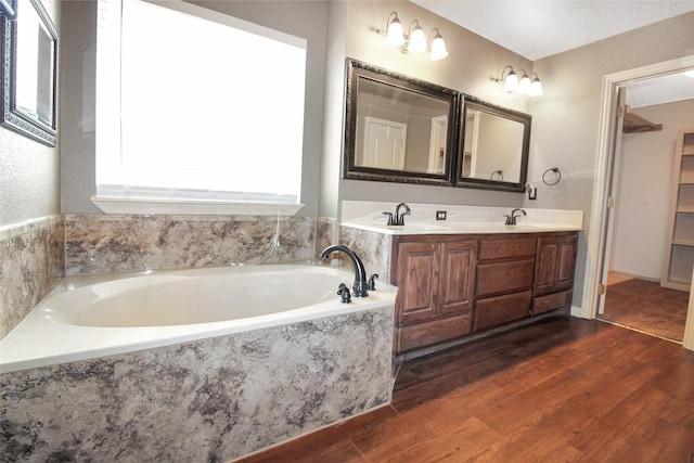 bathroom featuring vanity, hardwood / wood-style floors, and tiled tub