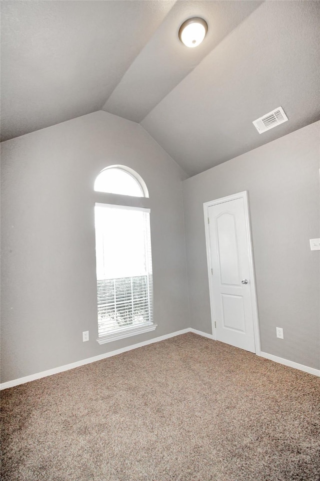 spare room featuring lofted ceiling and carpet floors