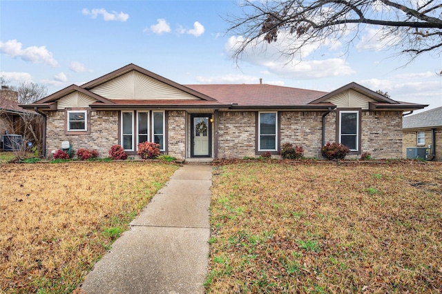 single story home with cooling unit and a front yard