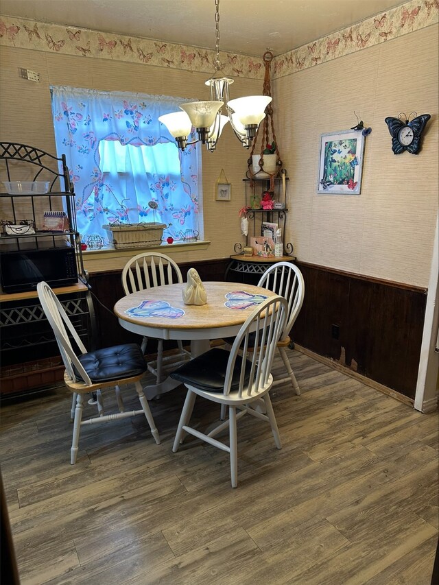 dining area featuring hardwood / wood-style flooring and a notable chandelier