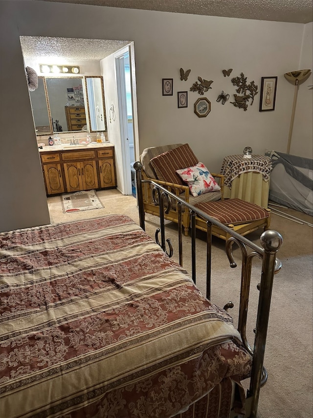 bedroom with light carpet, sink, connected bathroom, and a textured ceiling