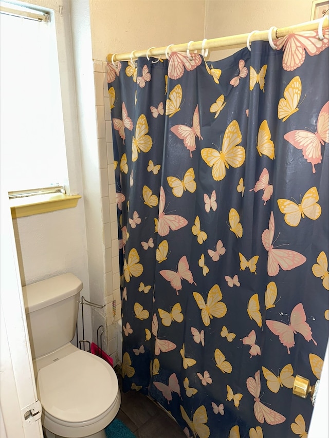 bathroom with a shower with curtain and toilet