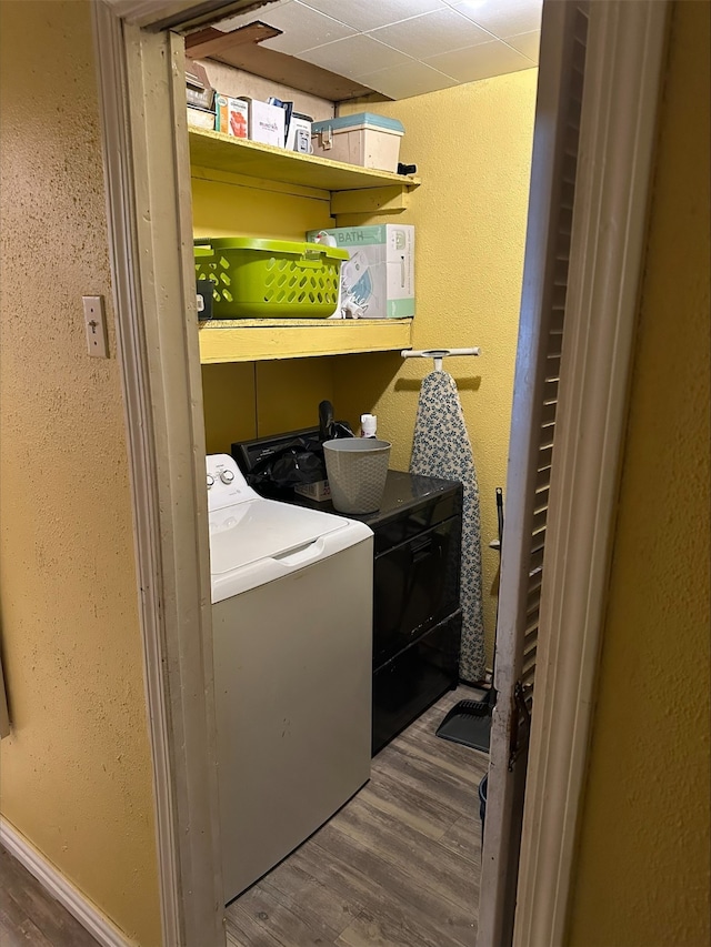 clothes washing area with washing machine and dryer and dark hardwood / wood-style floors