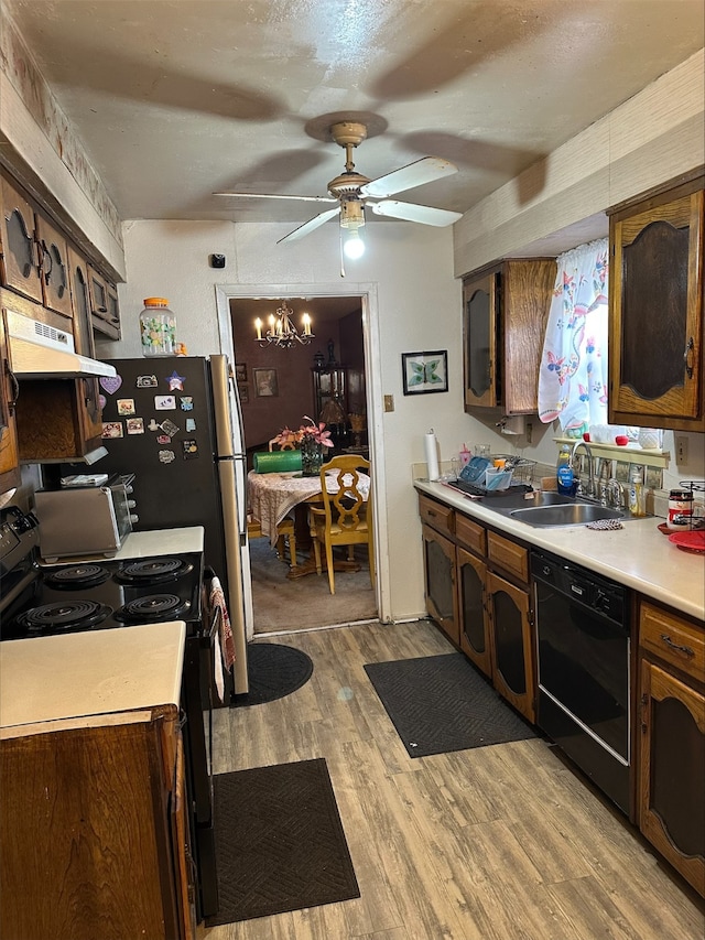 kitchen with dark brown cabinetry, sink, light wood-type flooring, and black appliances