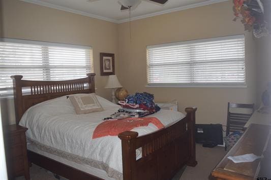 carpeted bedroom with crown molding and ceiling fan