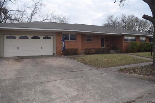 ranch-style home with a garage and a front lawn