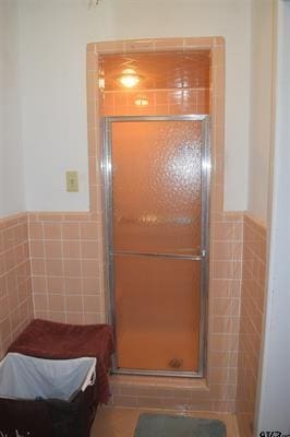 bathroom with walk in shower and tile walls