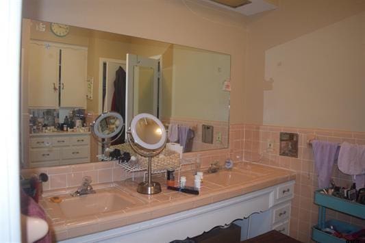 bathroom featuring sink and tile walls