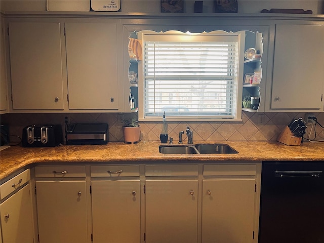 kitchen featuring dishwasher, sink, and white cabinets