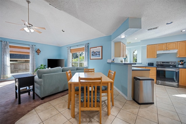 dining space with light tile patterned flooring, vaulted ceiling, ceiling fan, and a textured ceiling