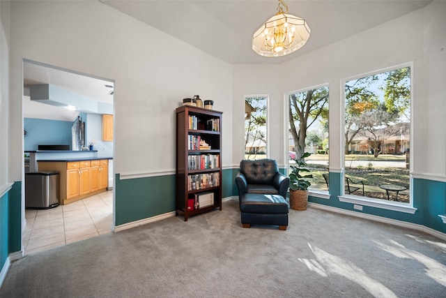 sitting room featuring a healthy amount of sunlight, light carpet, and a notable chandelier