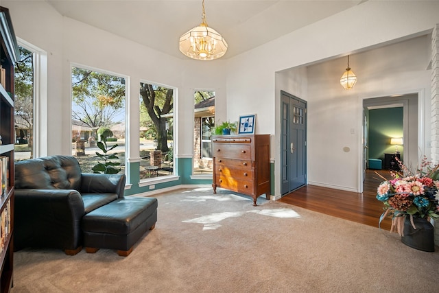 sitting room with an inviting chandelier and carpet floors