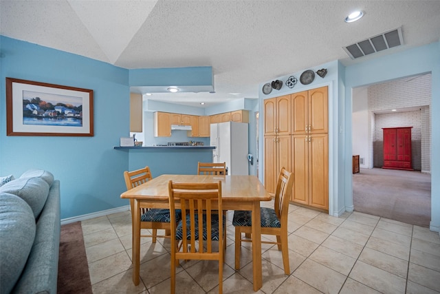 dining room featuring light tile patterned flooring and a textured ceiling