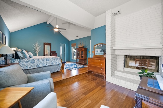 bedroom with vaulted ceiling with beams, a fireplace, and hardwood / wood-style floors