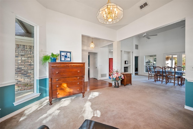 interior space with a fireplace, a chandelier, and a high ceiling