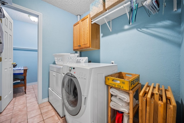 washroom featuring cabinets, independent washer and dryer, a textured ceiling, and light tile patterned flooring