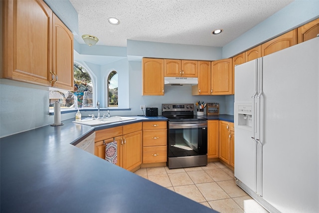 kitchen with sink, white appliances, light tile patterned floors, and a textured ceiling