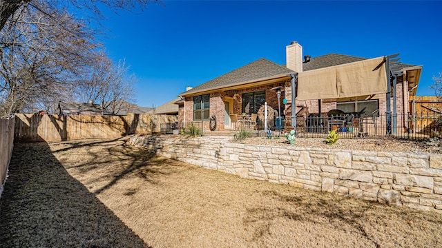 back of property featuring a patio area and a lawn