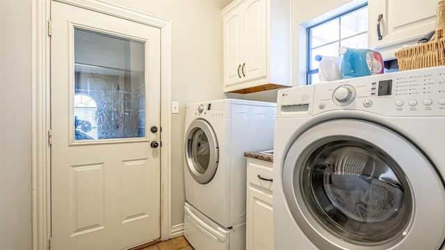 laundry room featuring cabinets, washing machine and dryer, and light tile patterned floors