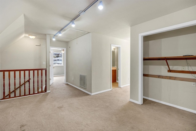 interior space with light colored carpet and track lighting