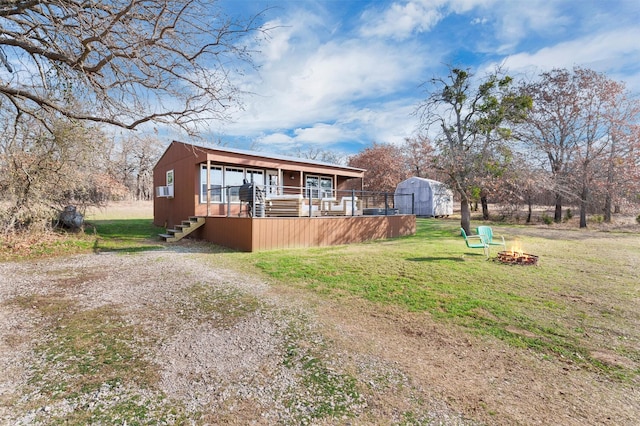 view of front of house with a front yard and an outdoor fire pit